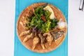 Fried fish in batter served with sliced Ã¢â¬â¹Ã¢â¬â¹onion rings, greens, dill, pears, cilantro and dried squid straws Royalty Free Stock Photo